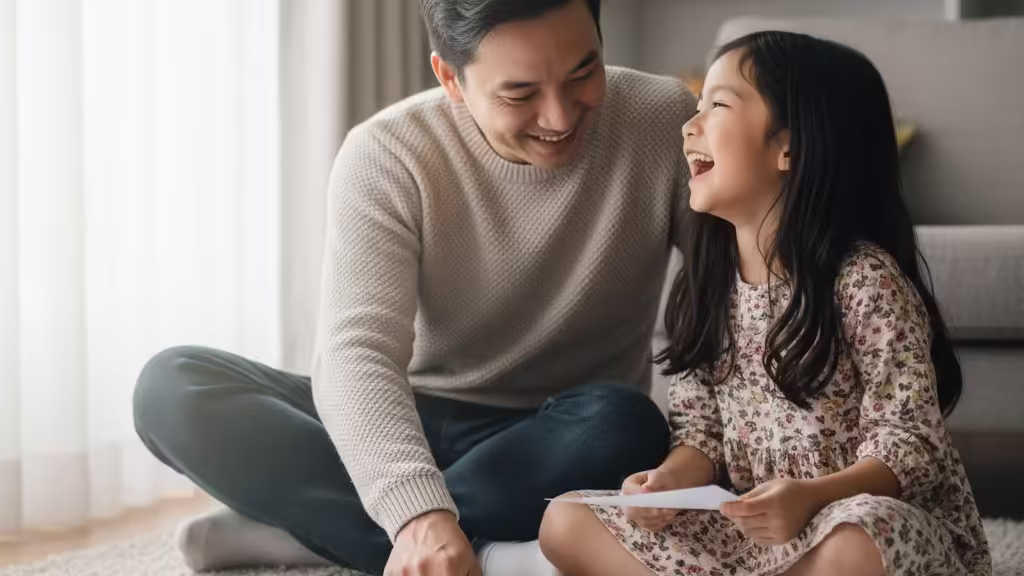 Cha và con gái đang vui vẻ tô màu cùng nhau, tạo nên khoảnh khắc gia đình ấm áp và ý nghĩa.